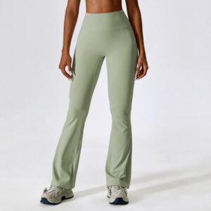 Woman wearing sage green high-waisted flare yoga pants with a seamless waistband, styled with sneakers for a casual active look