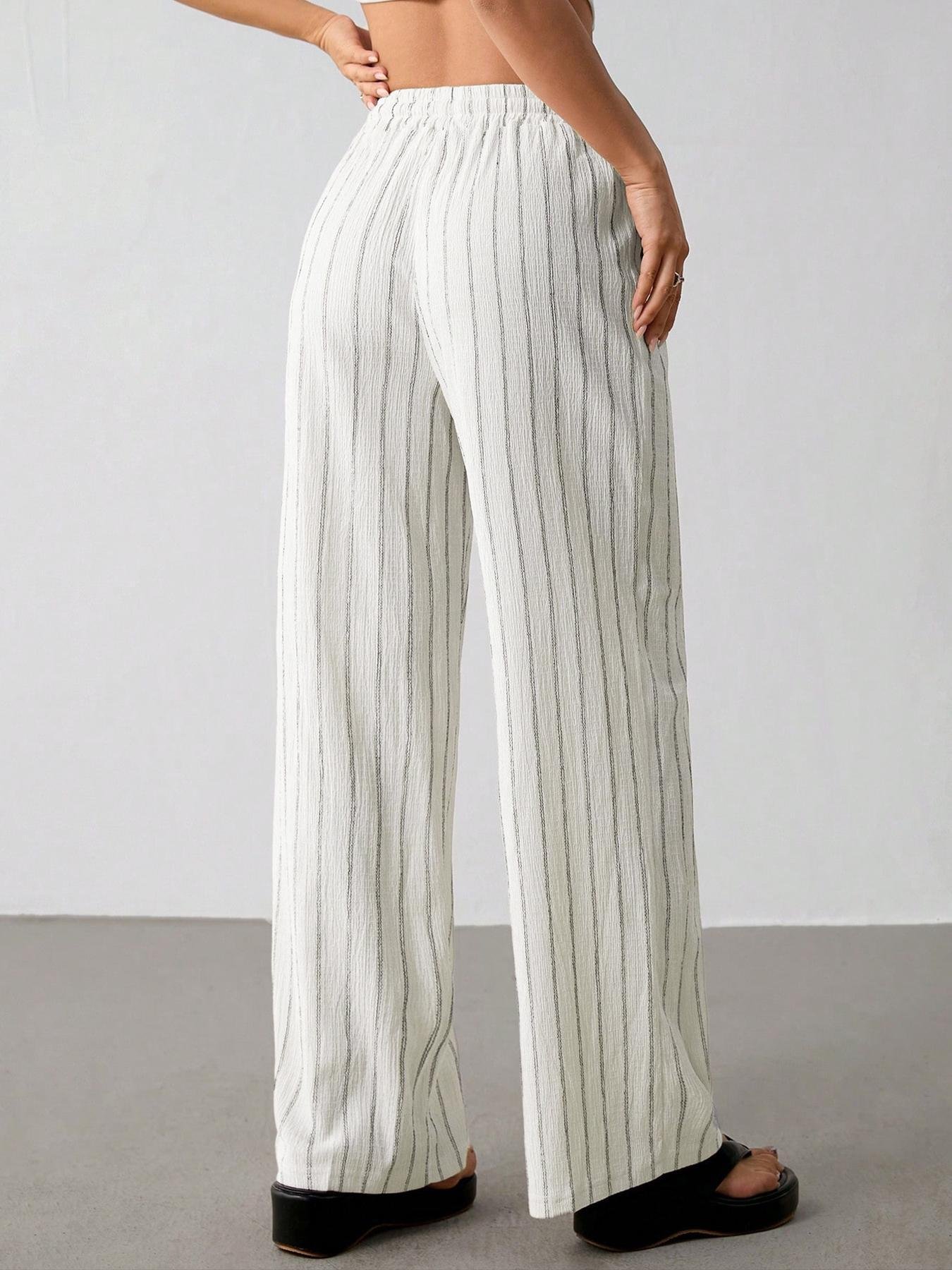 Off White Striped Wide Leg Pants Back Elastic Waist Crinkle Texture Back view cream white vertical striped palazzo pants, full elastic ruffle waistband, flowy wide leg cut, crinkle textured woven fabric minimalist indoor studio shot