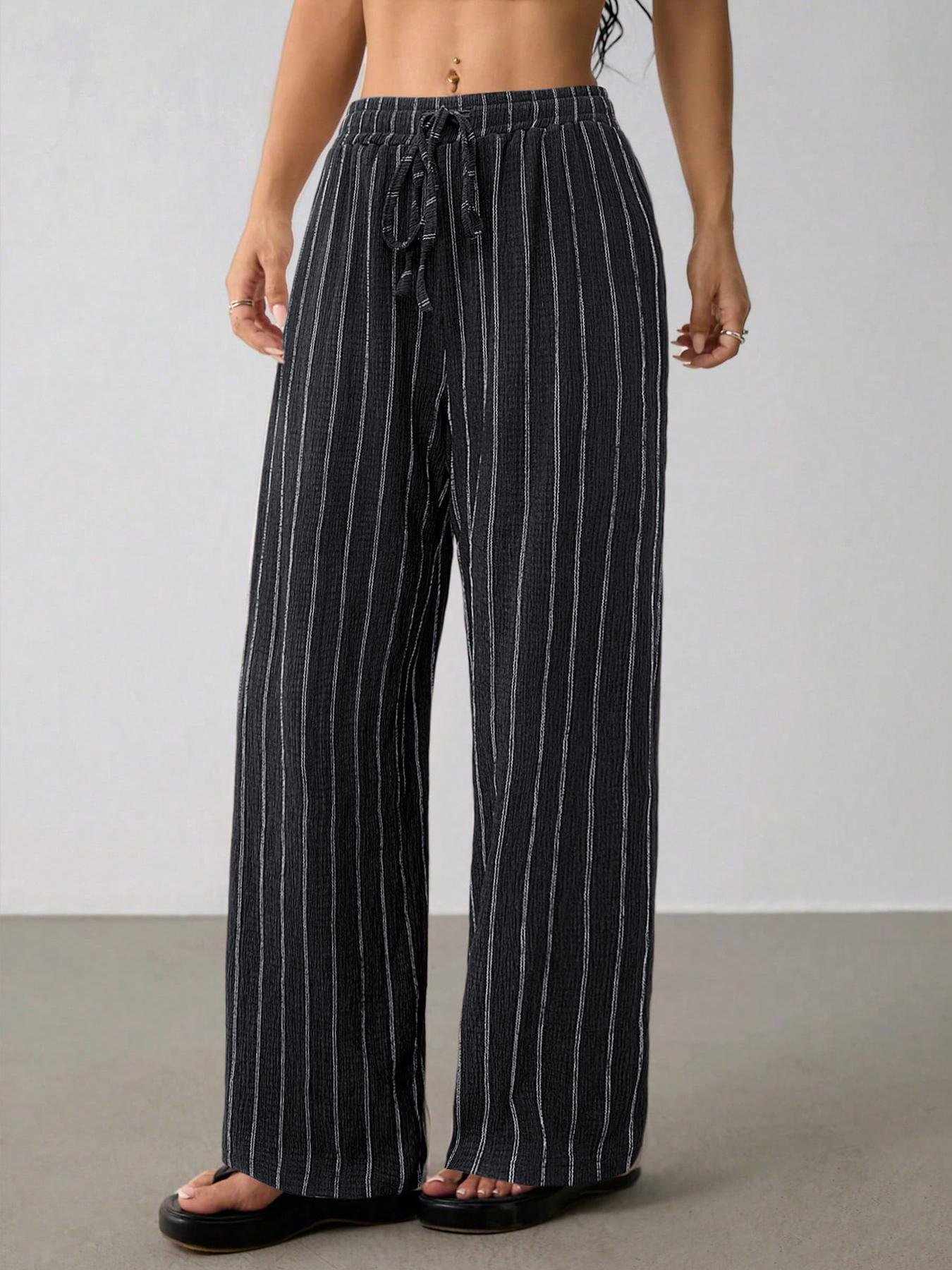 Navy Blue Striped Wide Leg Pants Loose Wide Leg Crinkle Palazzo Trousers Side angle navy vertical stripe loose wide leg trousers, stretch elastic waist, lightweight crinkle woven fabric, model with platform slide sandals indoor studio
