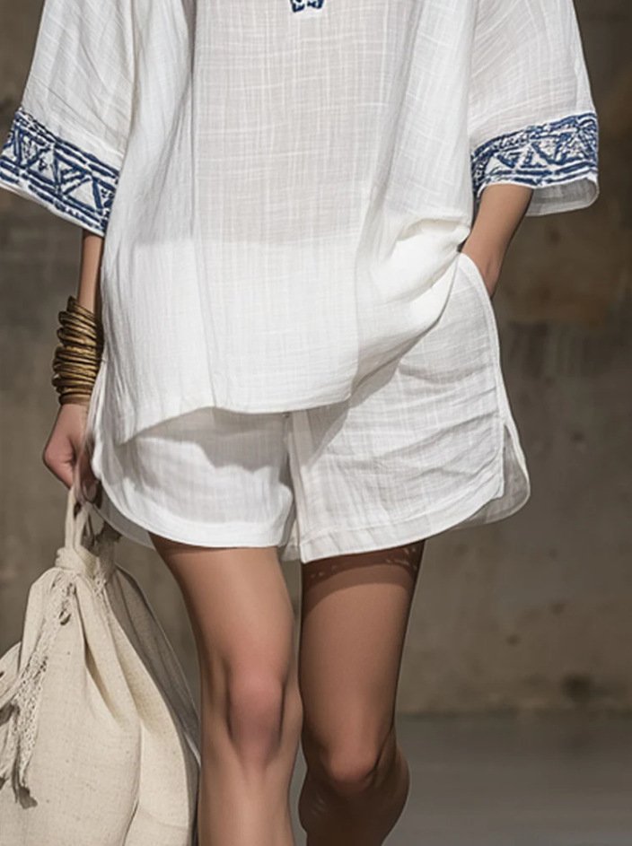 Close-up detail shot white boho embroidered v neck linen short set, blue tribal geometric cuff embroidery textured crinkle linen fabric functional side patch pocket loose linen short resort matching outfit