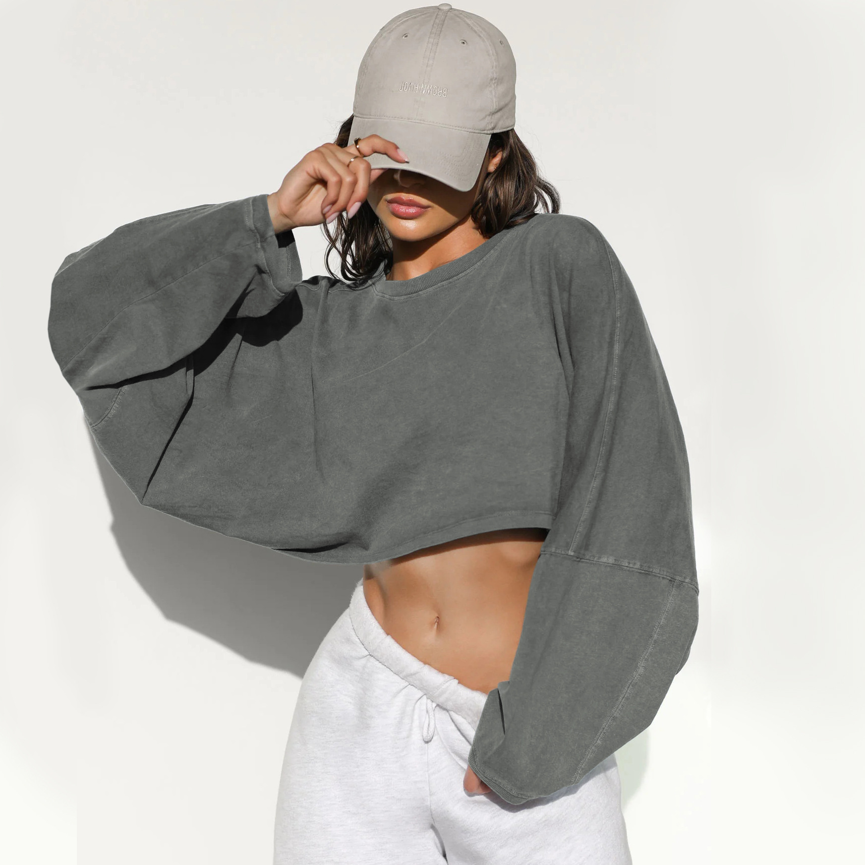 Gray Oversized Cropped Sweatshirt - Angled Front View Washed gray women's cropped oversized sweatshirt, long sleeve dropped shoulders, vintage wash fabric, casual everyday loungewear, angled view showing relaxed fit