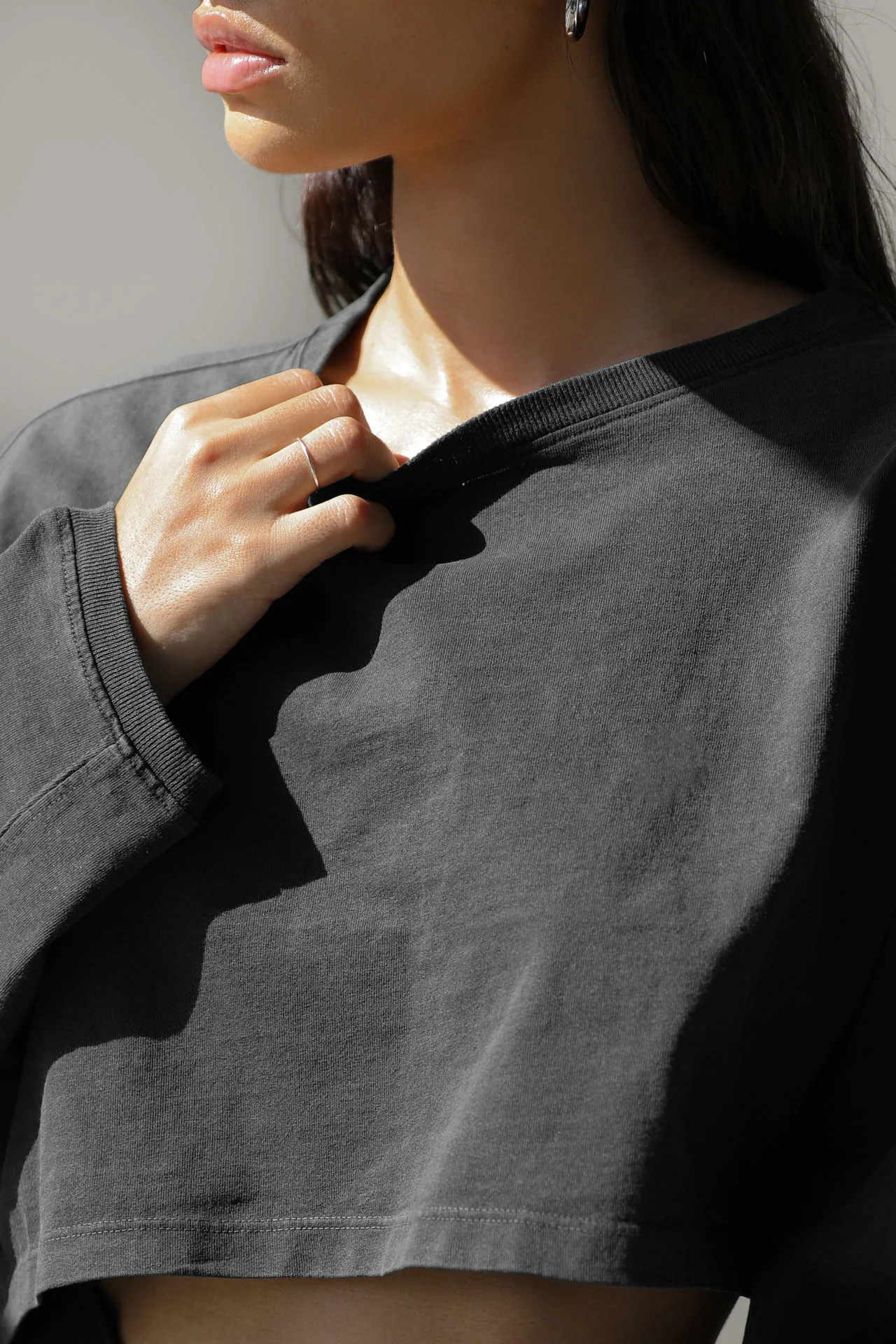 Gray Women's Cropped Sweatshirt - Close-Up Front View Close-up front view of washed gray women's cropped oversized sweatshirt, highlighting vintage fabric texture and loose long sleeve design, casual gym loungewear